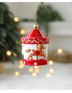 Detail showing hand-painted Christmas carousel ornament with gold glitter and red accents