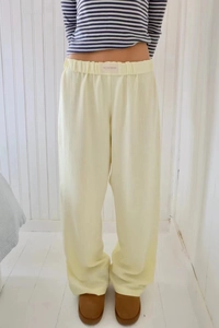 Detail of high waist striped wide leg trousers with elastic band and studio label