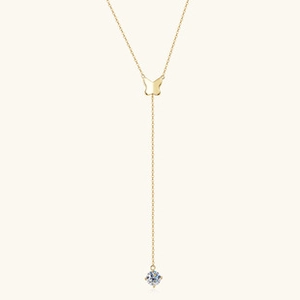 Macro view of gold butterfly Y-shaped necklace with a sparkling round gemstone drop