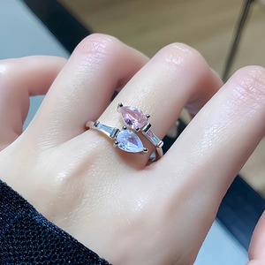 Detailed macro view of bypass ring featuring pink and blue pear-cut zircon stones