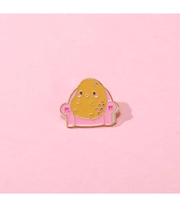 Détail d'un badge émaillé avec personnage de pomme de terre sur un fauteuil rose