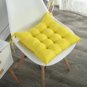 Detailed view of yellow padded chair cushion with quilted pattern and secure ties