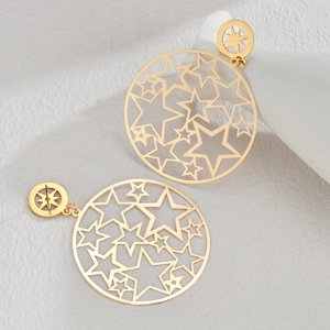 Detailed view of large golden openwork hoop earrings with star patterns on white background