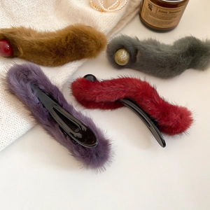 Detail showing acrylic plush hair clips in brown, grey, purple and red with bead accents