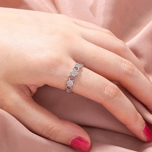 Detail of silver honeycomb ring with cubic zirconia stones on silk background