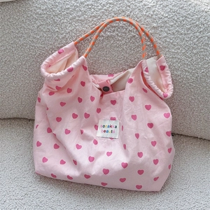 Detailed shot of pink heart canvas tote with thick rope handles and snap closure