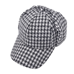 Detail of classic black and white houndstooth pattern on winter baseball cap with ear flaps