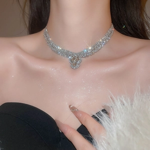 Close-up of multi-row rhinestone choker with pear-shaped pendant on female model
