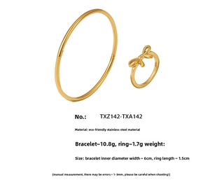 Detail of 18K gold PVD plated stainless steel bow ring and minimalist bangle set