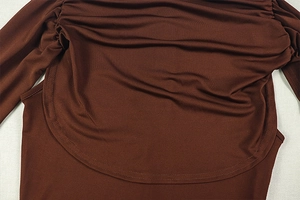 Macro detail of dark brown ruched fabric showing stitch texture and pleated design