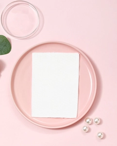 Close-up of soft cotton wet wipe texture on a pink plate with decorative pearls