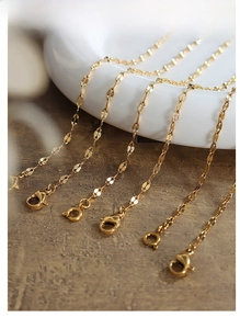 Detailed macro of gold lip-shaped link chain with lobster claw and spring ring clasps