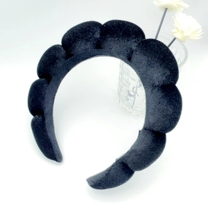 Detail of a thick padded black velvet sponge headband with cloud bubble wave design