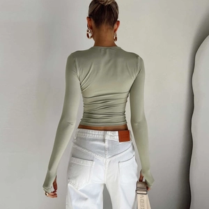 Close-up of the sage green long sleeve top featuring slim fit knit texture and cropped hem
