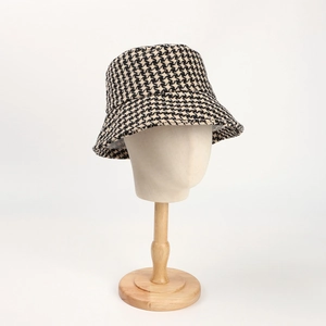 Detailed close-up of a thick houndstooth bucket hat on a wooden mannequin display