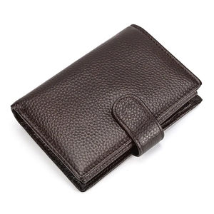 Detailed view of dark brown pebbled leather texture on a compact tri-fold wallet with strap