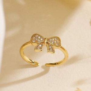 Detailed view of a gold bow ring featuring sparkling zircon pavé and adjustable open band