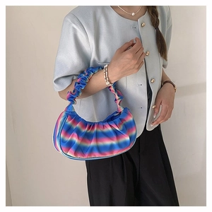 Detailed close-up of rainbow pleated cloud bag showing the vibrant gradient fabric textures