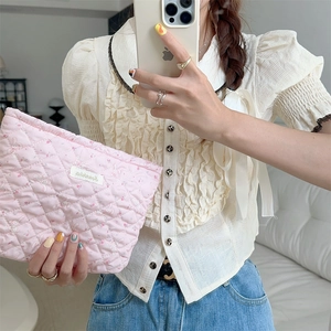 Close-up of pink quilted makeup bag with cute rabbit and flower pattern for travel