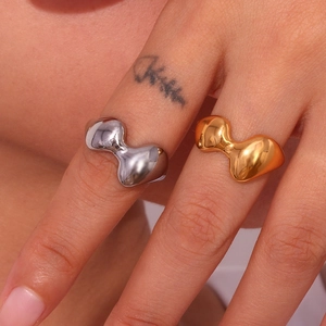 Detail of irregular lava texture rings in gold and silver finish on a model's hand