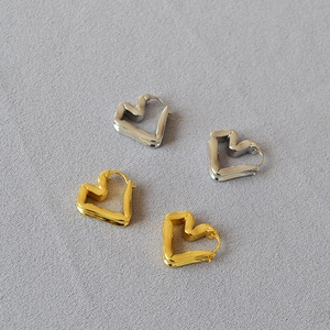 Detailed view of hollow heart-shaped geometric hoop earrings in gold and silver finish