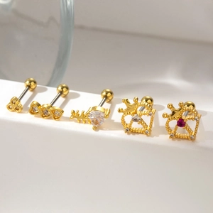Detail view of five gold-tone heart and crown cartilage studs with zircons