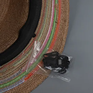 Close-up of woven straw hat with colorful striped lining and detachable windproof rope