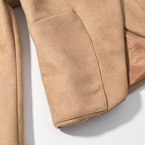 Macro detail of camel faux suede jacket showing precise stitching and soft fabric texture