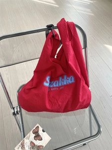 Sac fourre-tout rouge en toile avec imprimé Stakka suspendu à une chaise moderne