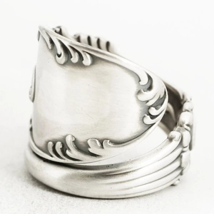 Macro detail of vintage silver spoon ring featuring intricate baroque floral relief