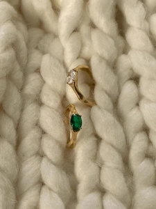 Elegant 925 sterling silver rings with green and white oval gemstones on white knit fabric