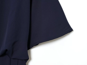 Détail de la robe midi bleu marine montrant la texture plissée et la coupe de précision
