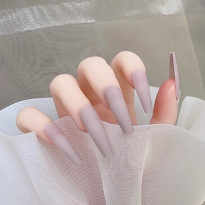 Détail de faux ongles mats longs ballerine couleur mauve poudré élégant à presser