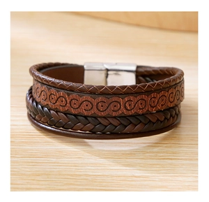 Close-up of brown multi-layer braided leather men's bracelet with silver metal S-pattern magnetic clasp