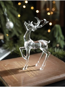 Detailed view of clear acrylic Christmas reindeer figurine on a vintage book