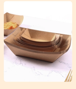 Multiple sizes of stacked brown kraft paper food trays for disposable takeout packaging