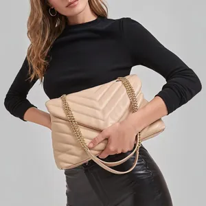 Quilted beige shoulder bag with V-shaped stitching and dual golden metal chain straps
