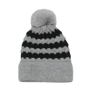 Detail of grey and black wavy knit beanie with a large faux fur pompom and ribbed cuff