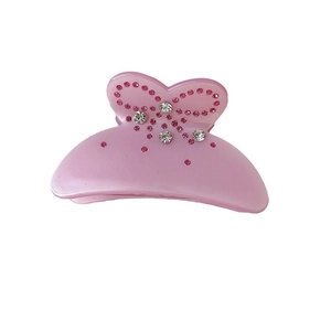 Pink bow hair claw clip with rhinestones made of acetate, 45-degree angle product view