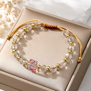 Detail of beaded evil eye bracelet with clear crystals and adjustable gold cord
