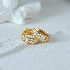 Close-up of classic gold-plated S925 silver huggie earrings with double rows of pavé zircons