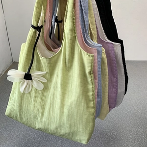 Close-up of seersucker tote bags in multiple colors featuring textured pleated fabric