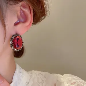 Vintage oval red zircon stud earrings with silver engraved hollow base on a model