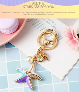 Close-up of ocean-themed starfish keychain with blue enamel, pearl and shell charms