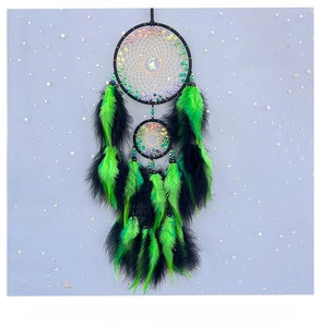 Close-up of black and green double ring dreamcatcher with feathers and moon charm