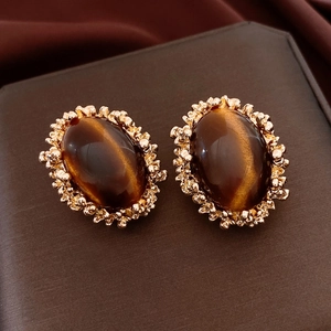 Close-up of vintage court style oval tiger eye earrings in gold textured settings