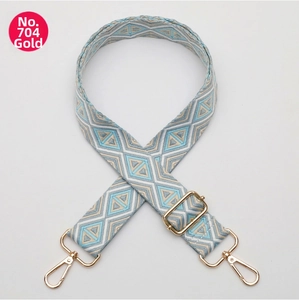 Detail of adjustable geometric diamond pattern bag strap with gold metal lobster clasps