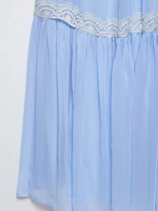 Close-up of light blue chiffon dress featuring delicate white lace trim and pleated texture