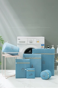 Five-piece blue mesh laundry bag set with various garment icons in a modern laundry room