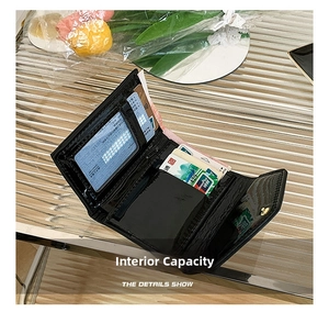 Detail of the trifold black glossy leather wallet with multiple card slots and ID window